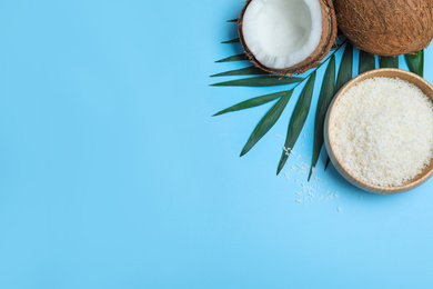 Flat lay composition with fresh coconut flakes on light blue background. Space for text
