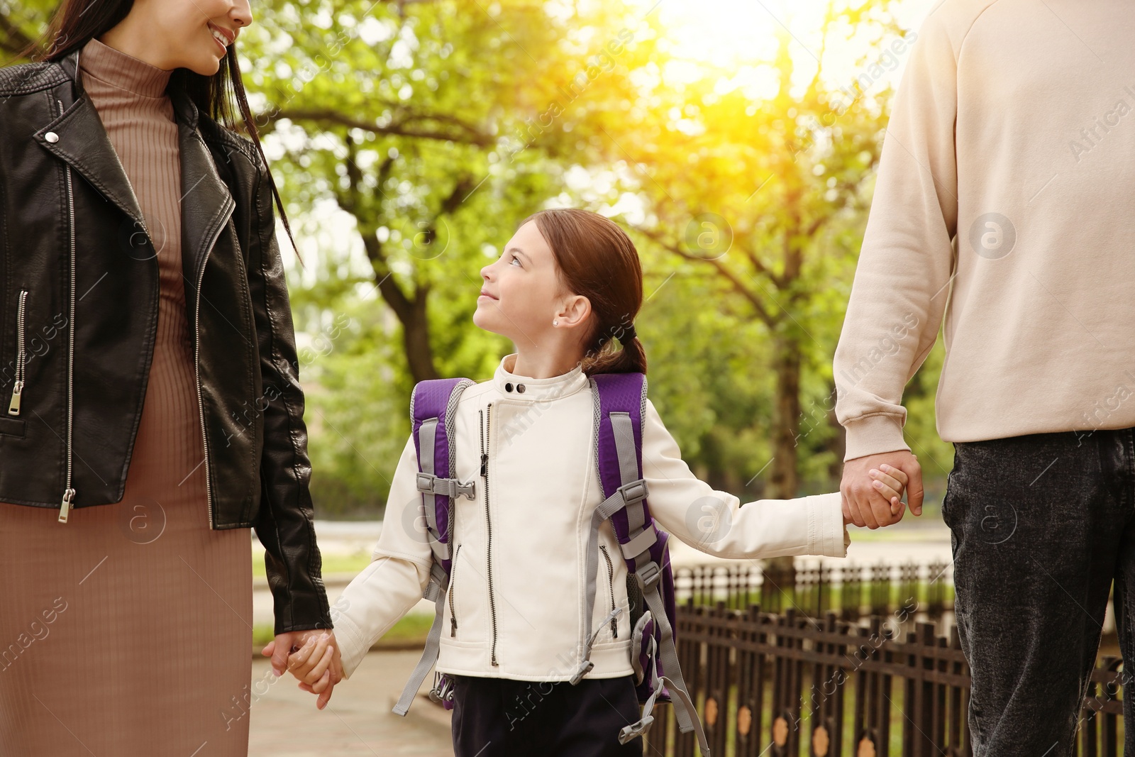 Image of Parents taking their little daughter to school outdoors