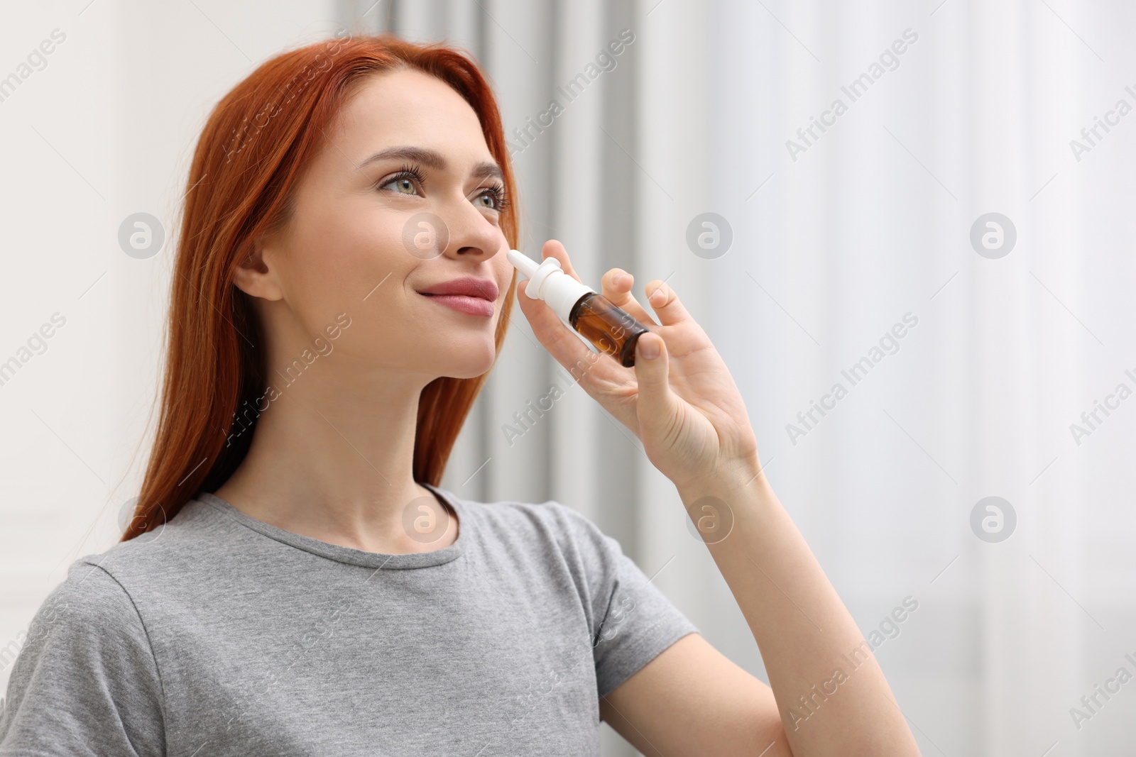 Photo of Medical drops. Woman using nasal spray at home, space for text