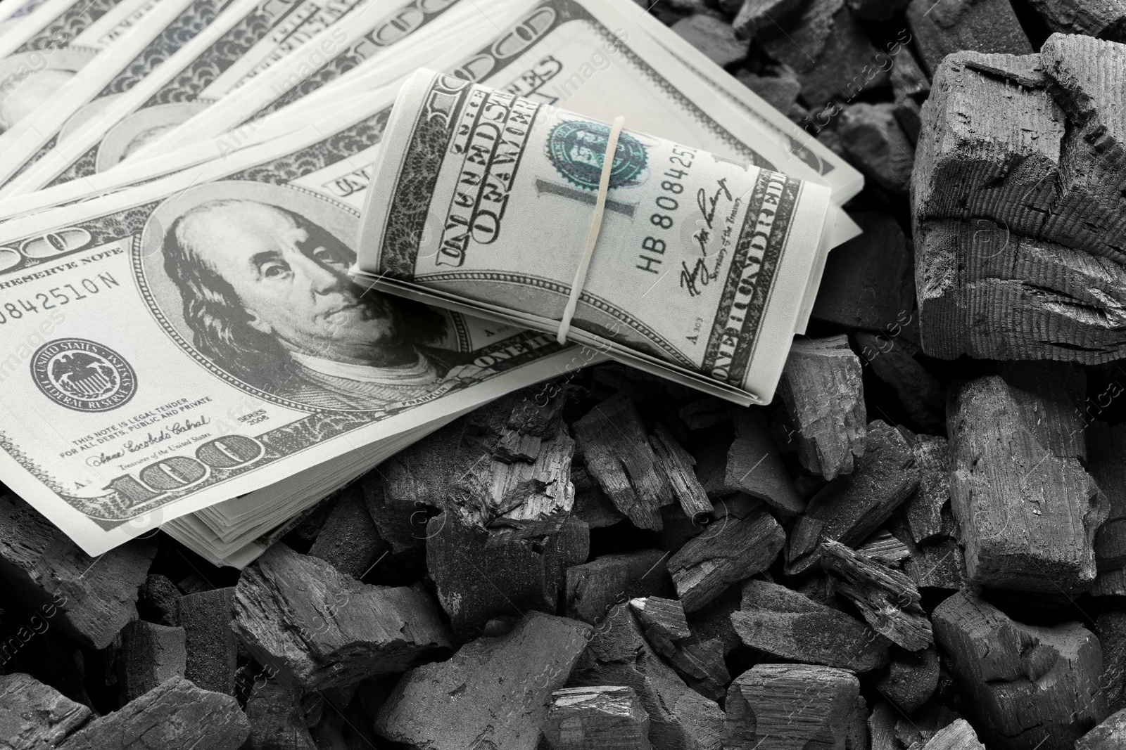 Image of Dollar banknotes on pieces of coal, closeup. Resource price