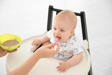 Mother feeding her cute little baby at home