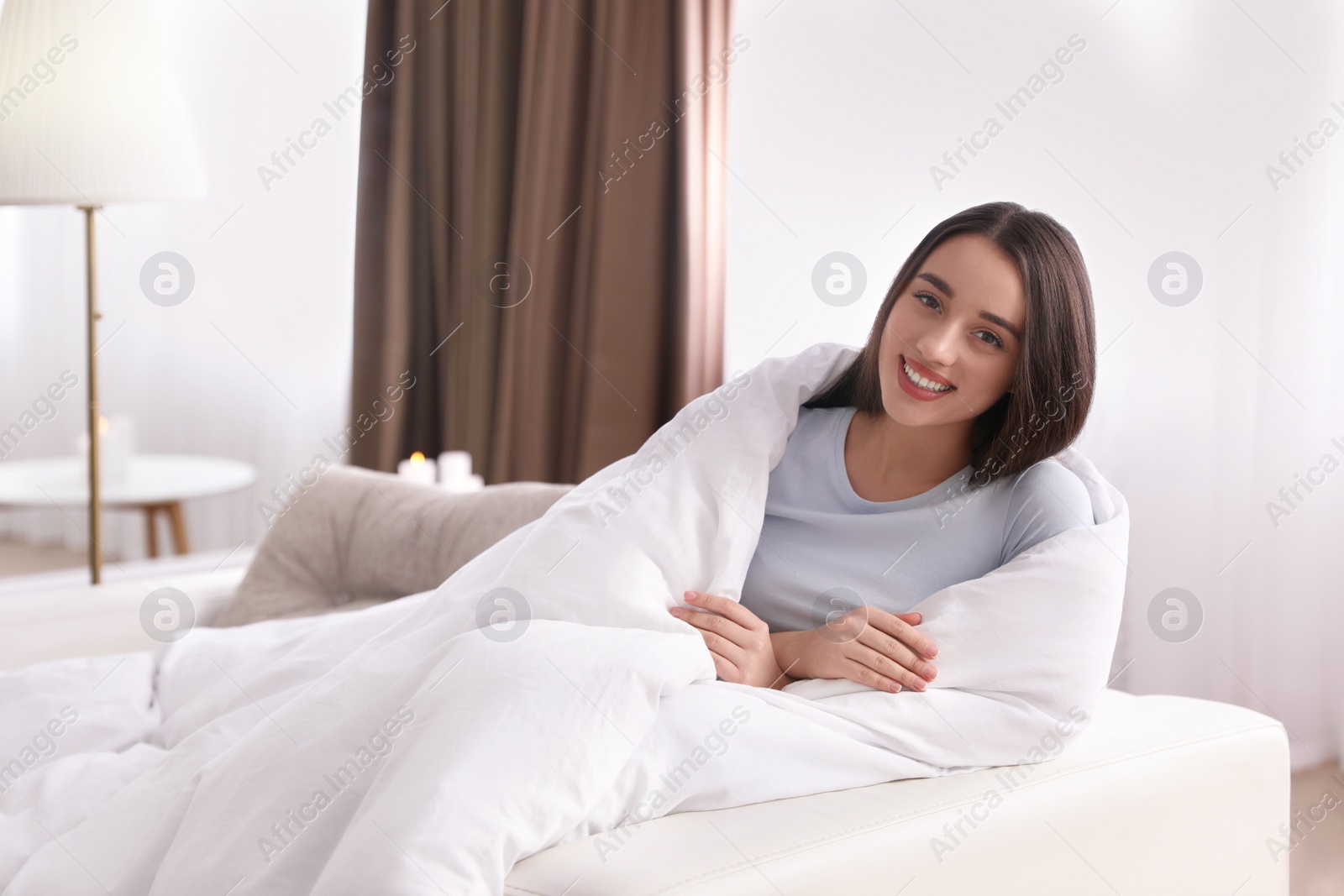 Photo of Woman covered in blanket resting on sofa, space for text