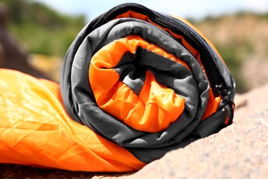 Rolled sleeping bag outdoors on sunny day, closeup