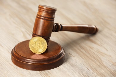 Photo of Law concept. Gavel and bitcoin on wooden table, closeup