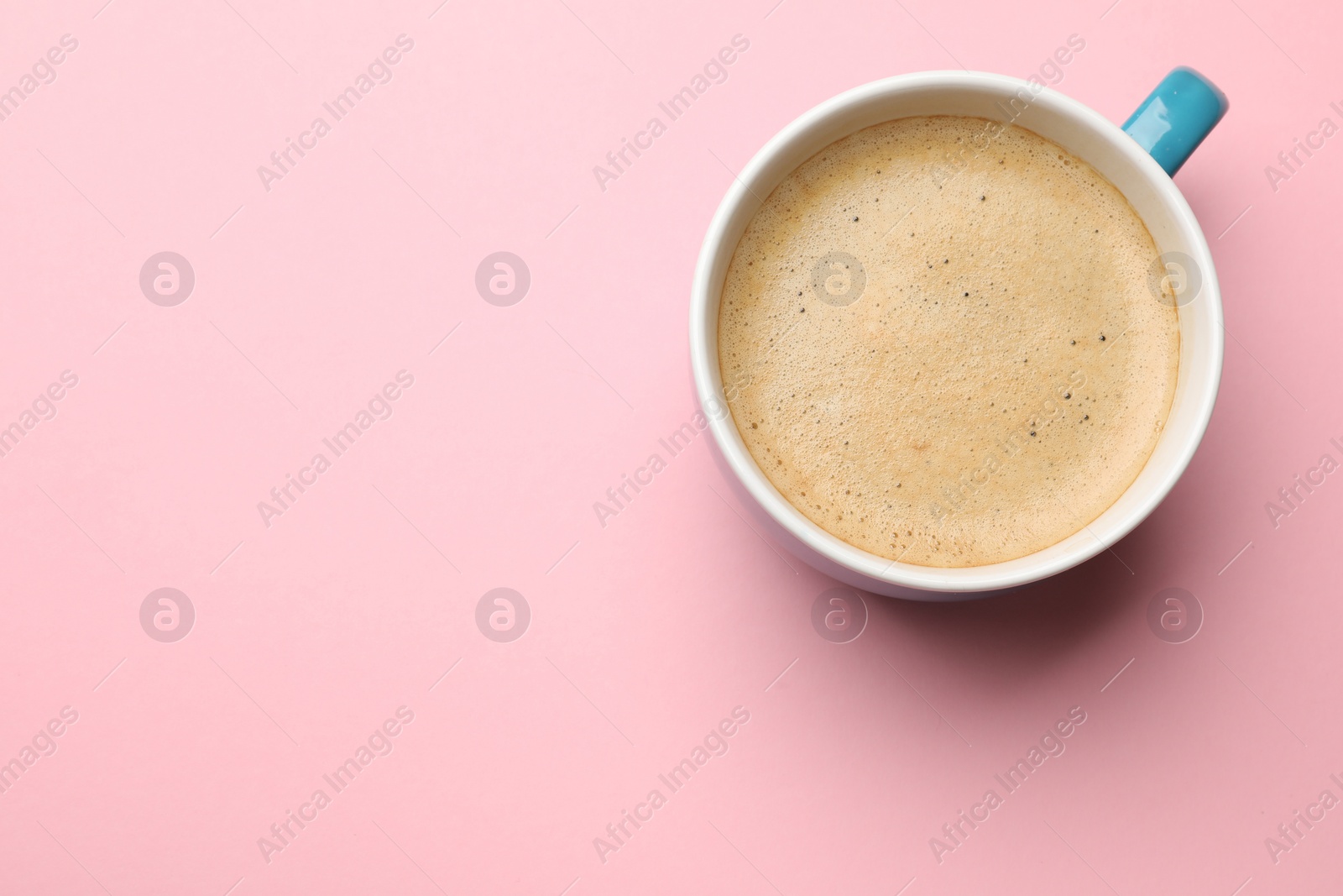 Photo of Fresh coffee in cup on pink background, top view. Space for text