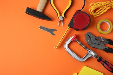 Photo of Set of repair tools on orange background, flat lay. Space for text