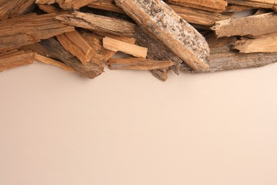 Wood chips on beige background, flat lay. Space for text