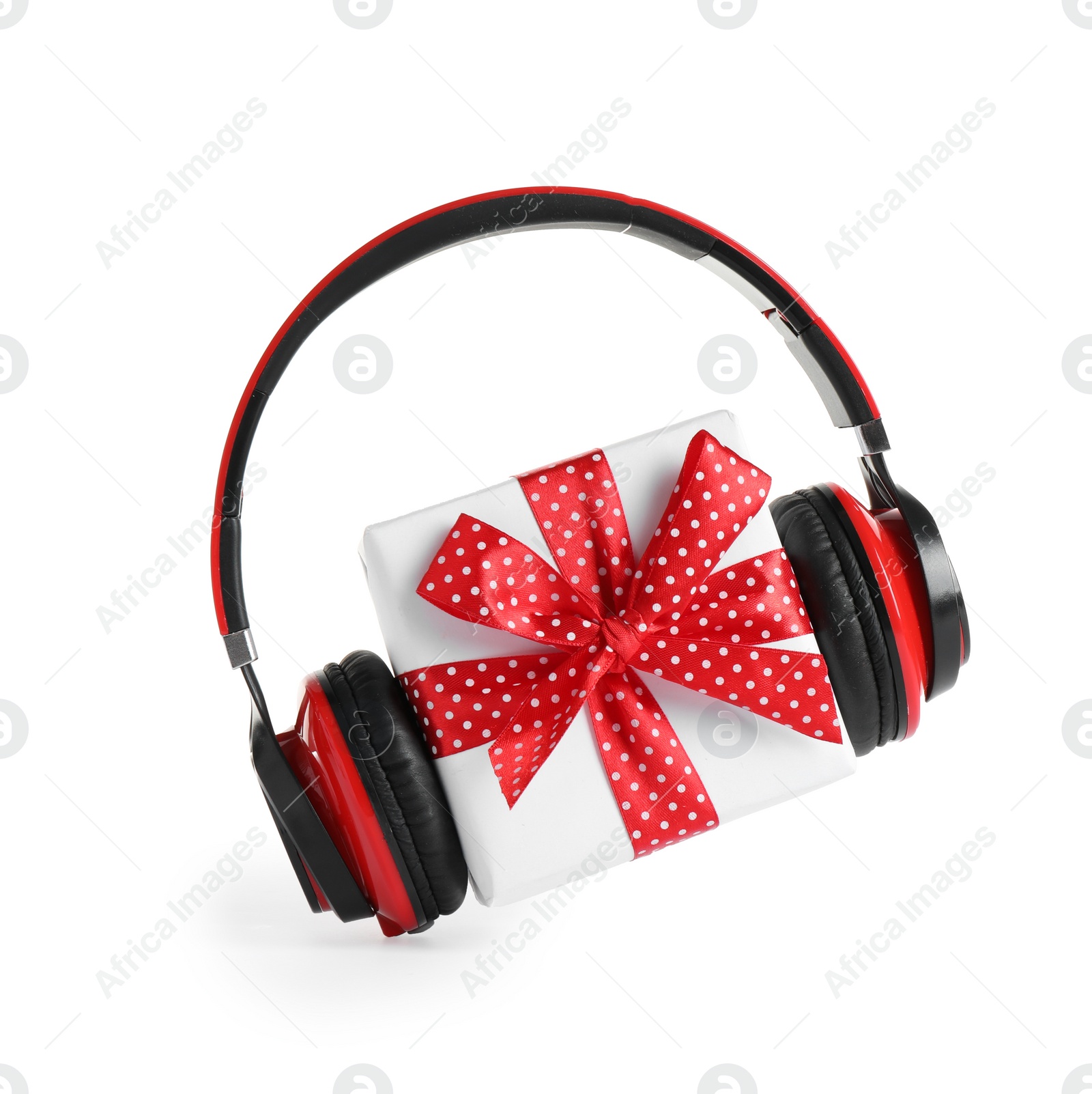 Photo of Gift box with headphones isolated on white. Christmas music concept