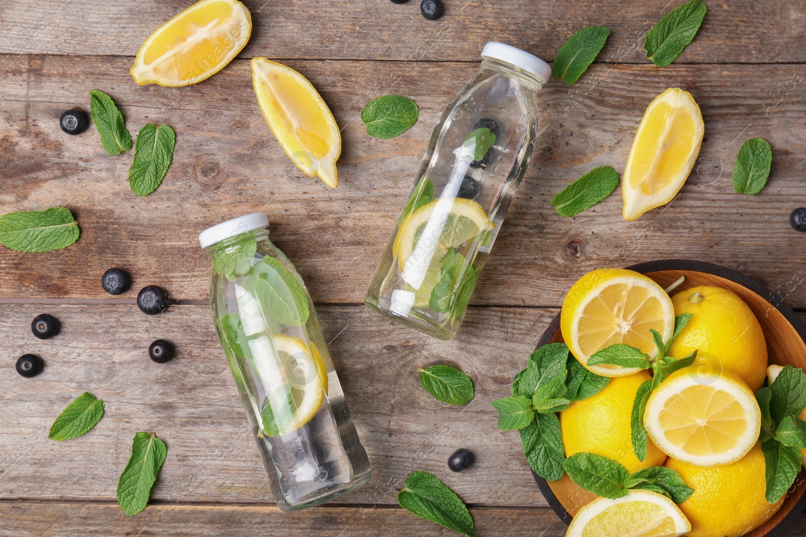 Photo of Flat lay composition with detox lemonade and ingredients on wooden background