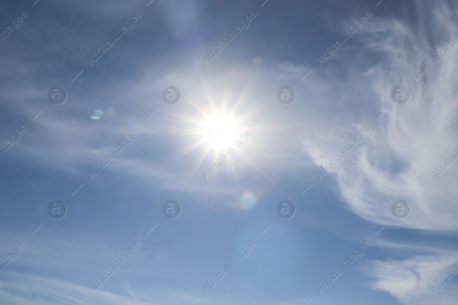 Photo of Bright sun and fluffy white clouds in blue sky