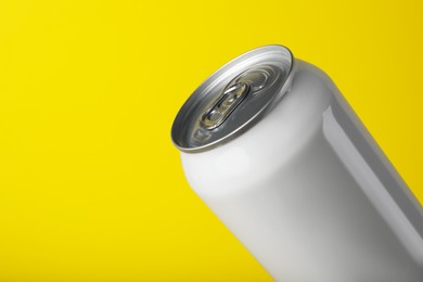 Photo of White can of energy drink on yellow background, closeup. Space for text