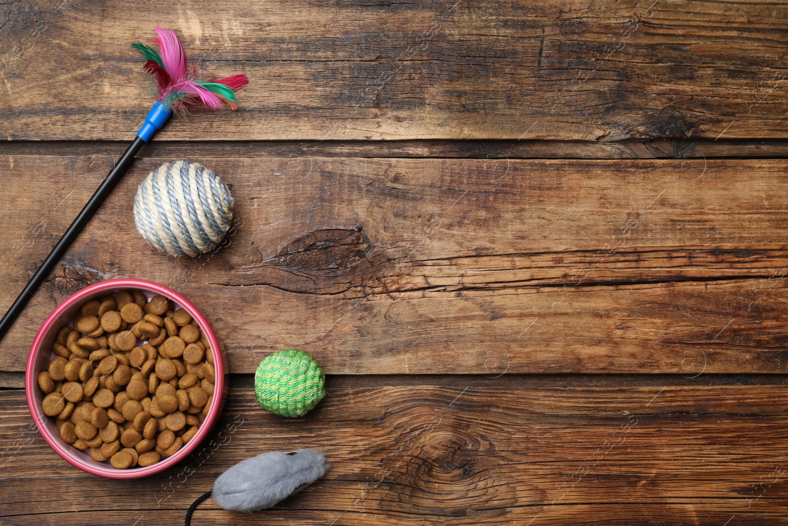 Photo of Flat lay composition with different pet toys and feeding bowl on wooden background, space for text