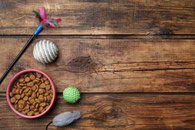 Photo of Flat lay composition with different pet toys and feeding bowl on wooden background, space for text