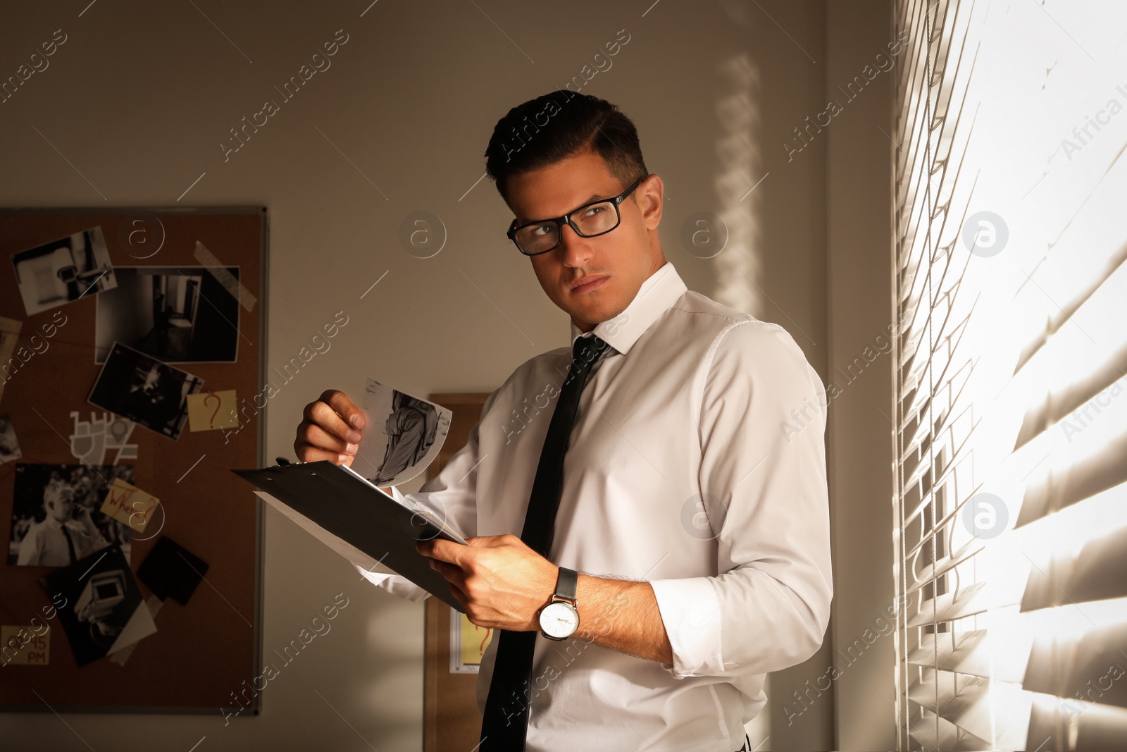 Photo of Detective with clipboard working in his office