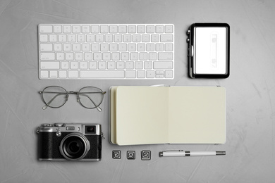 Photo of Flat lay composition with equipment for journalist on grey stone table