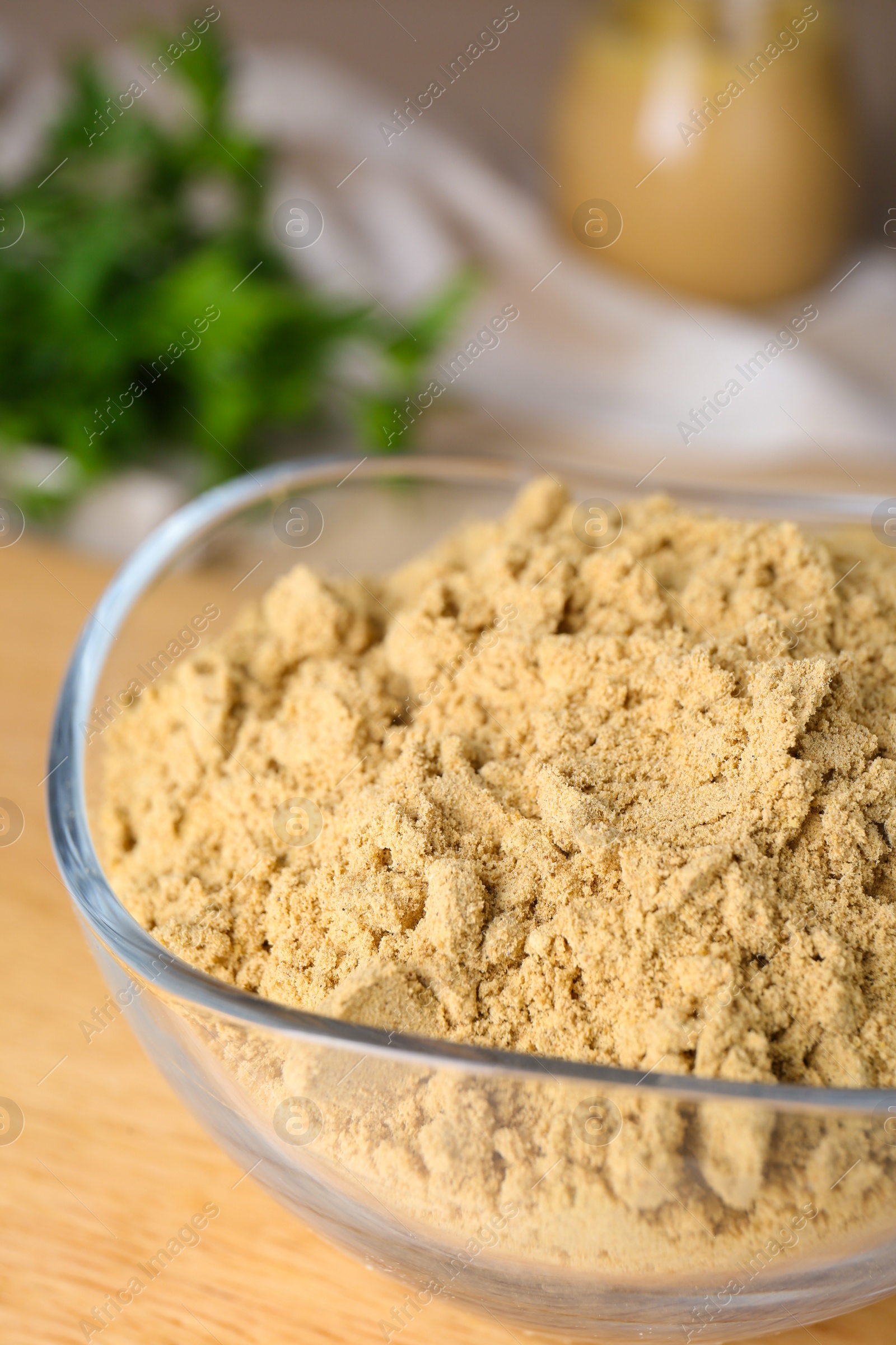 Photo of Bowl of aromatic mustard powder on table, closeup