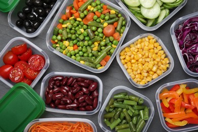 Photo of Set of plastic containers with fresh food on black table, flat lay