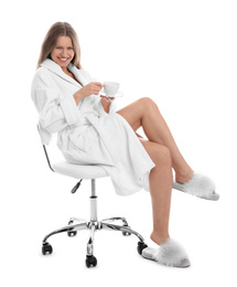 Photo of Young woman in bathrobe with cup of beverage on white background
