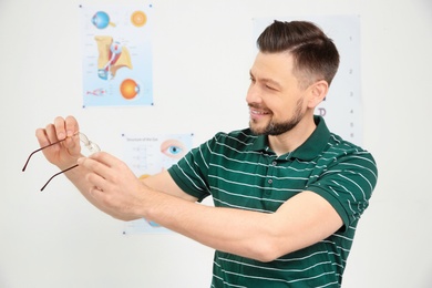 Photo of Young man with glasses visiting ophthalmologist