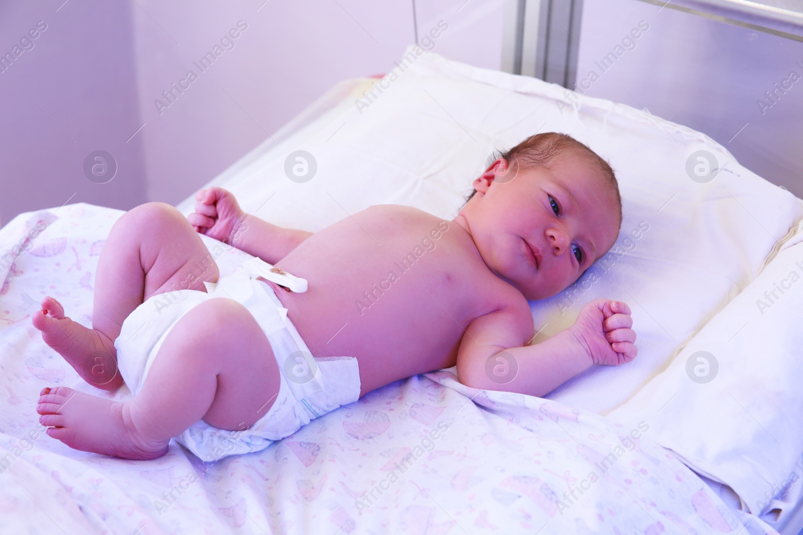 Photo of Newborn child under ultraviolet light in hospital