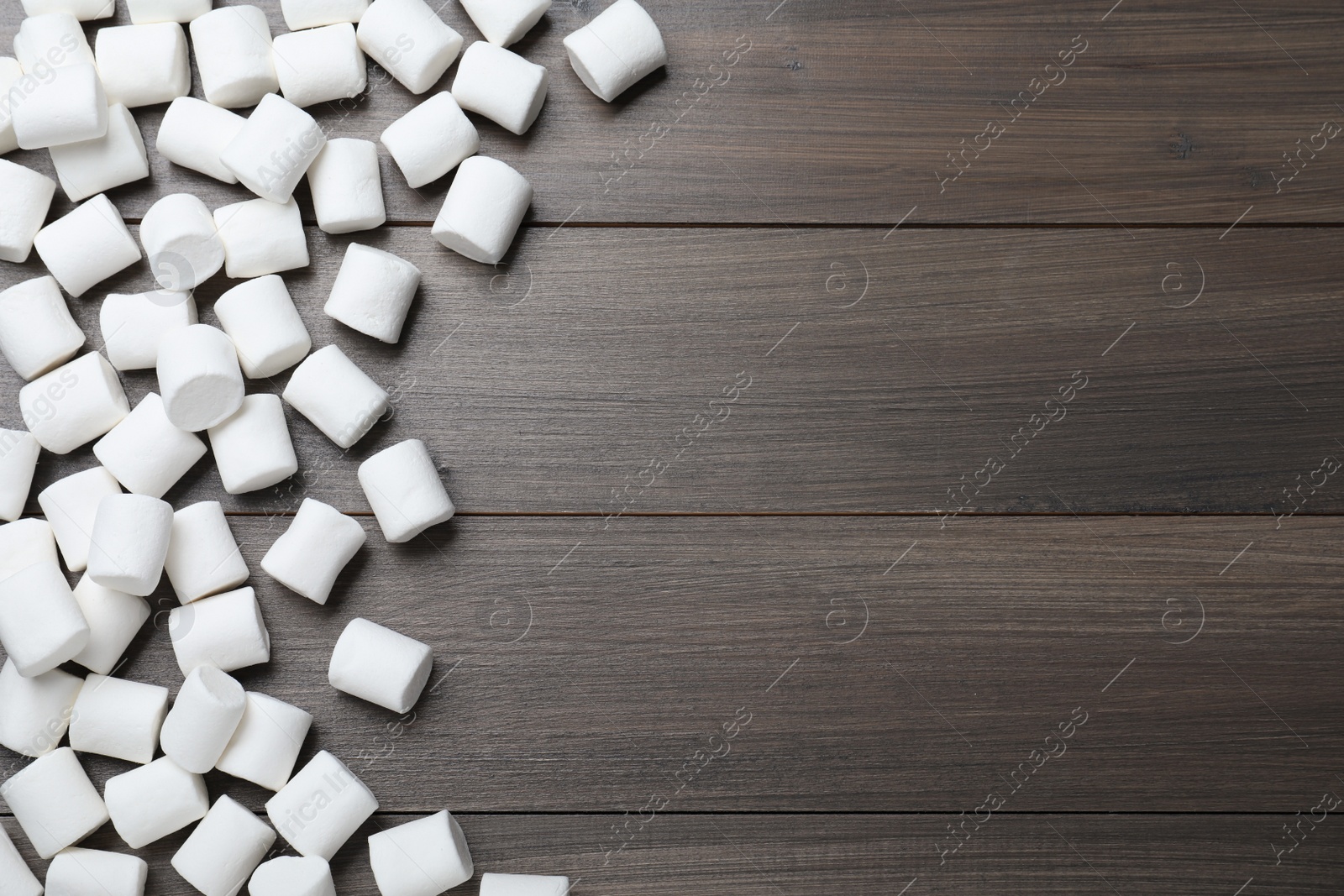 Photo of Delicious puffy marshmallows on wooden table, flat lay. Space for text