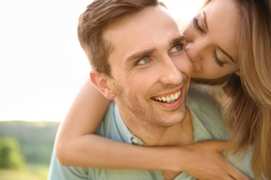 Cute young couple in love posing outdoors on sunny day