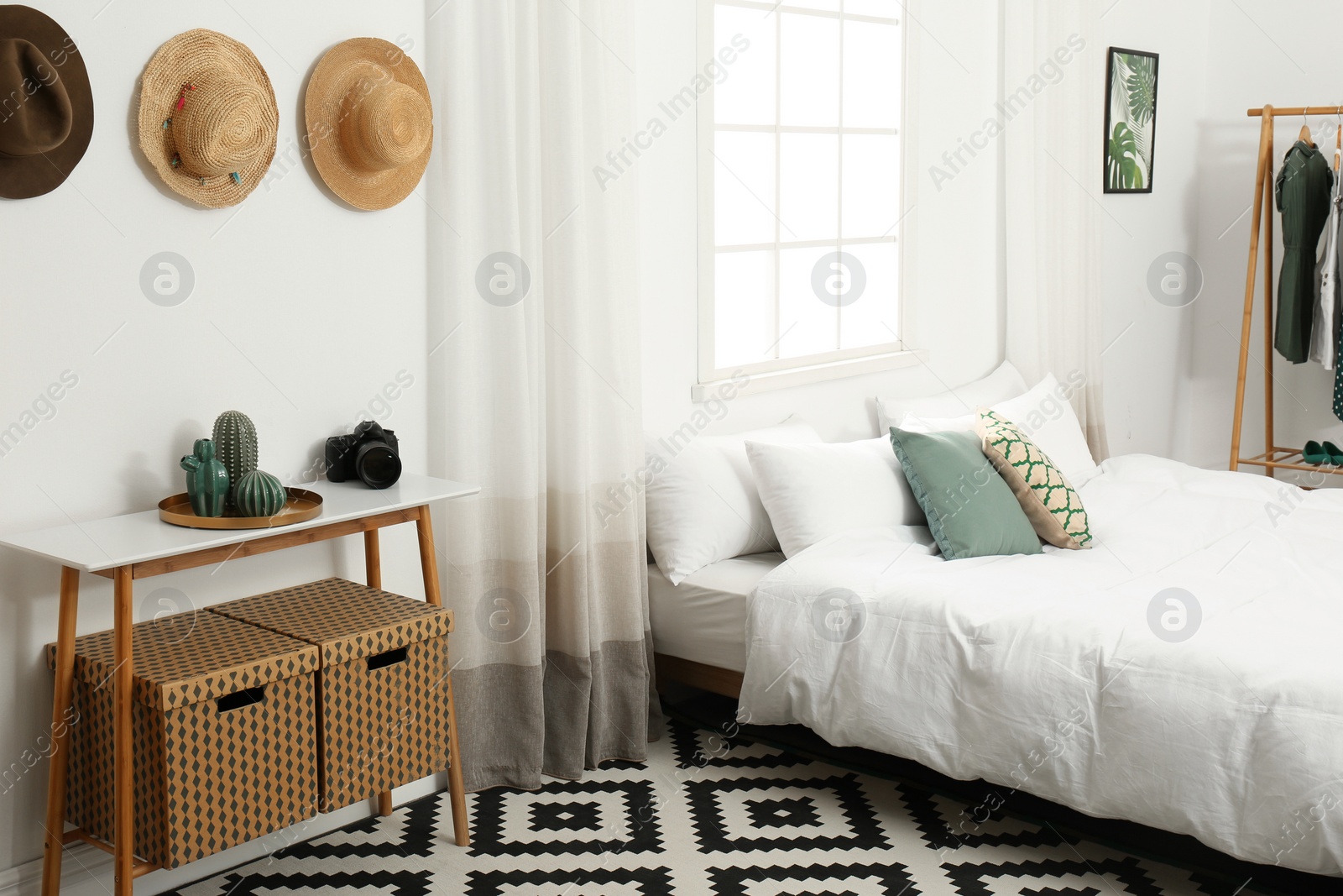 Photo of Stylish wooden table and bed in modern room interior