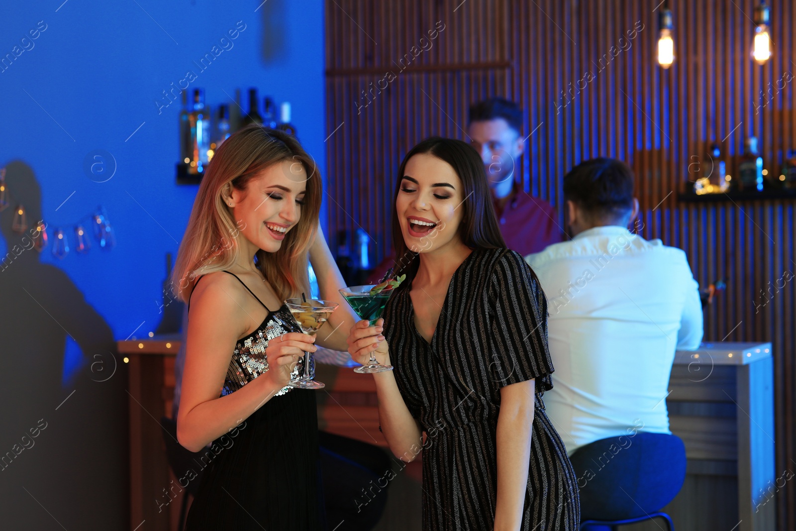 Photo of Beautiful young women with martini cocktails in bar