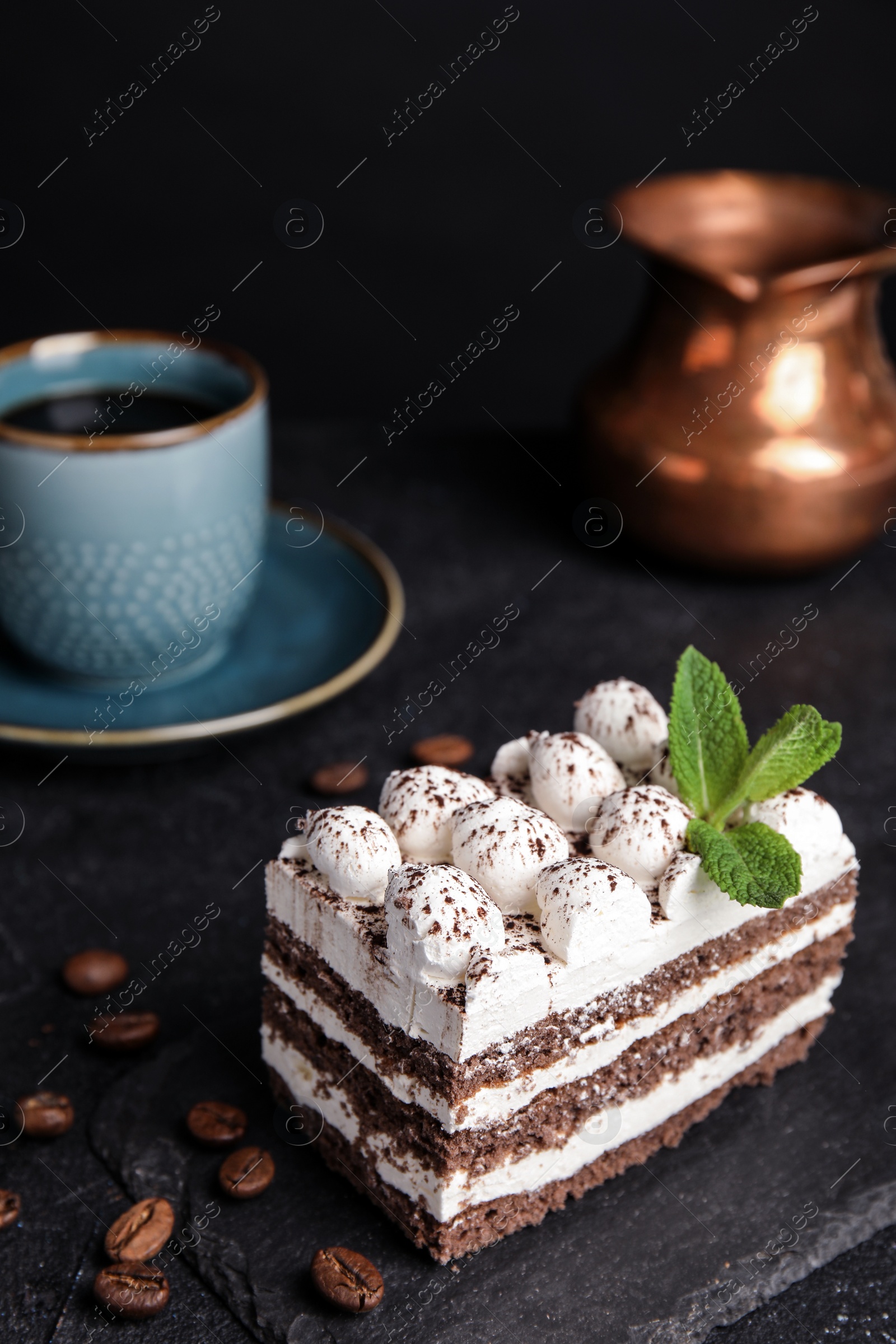 Photo of Composition with tiramisu cake on table against dark background