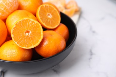 Photo of Fresh juicy tangerines on white marble table, closeup. Space for text