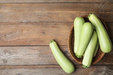 Photo of Ripe zucchinis on wooden table, flat lay. Space for text