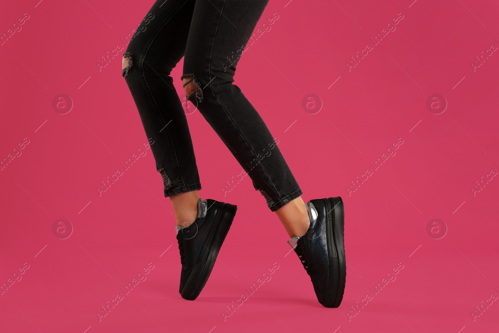 Photo of Woman wearing shoes on pink background, closeup