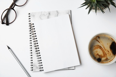 Photo of Flat lay composition with notebooks and coffee on white background