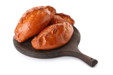 Wooden board with delicious baked patties on white background