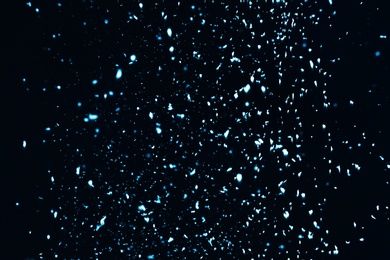 Photo of Snow flakes falling on black background. Winter weather