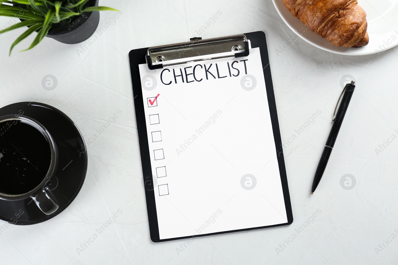 Photo of Clipboard with inscription Checklist, cup of coffee and croissant on white table, flat lay