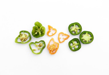 Different cut hot chili peppers on white background, flat lay