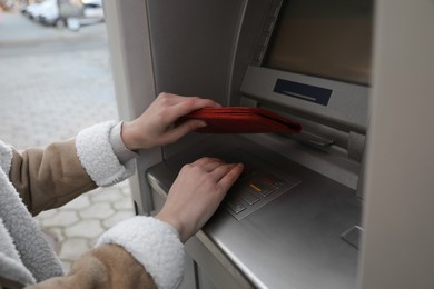 Woman entering cash machine pin code, closeup