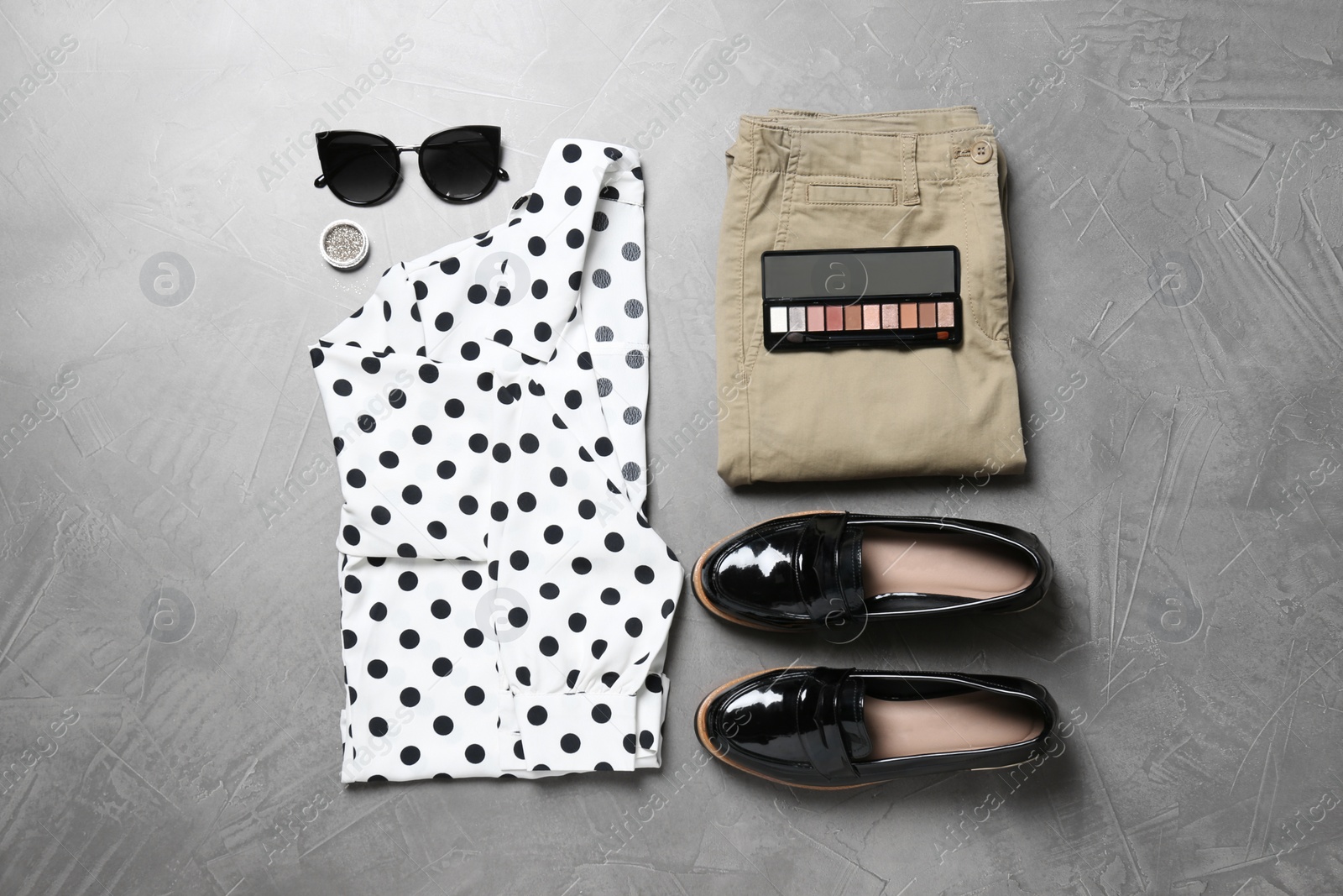 Photo of Women's clothes and makeup products on grey background, flat lay