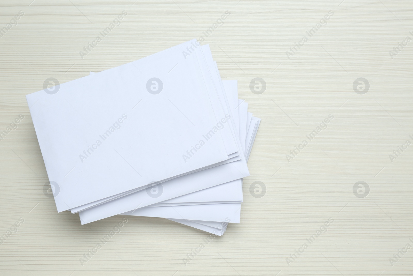 Photo of Stack of letters on wooden table, top view. Space for text