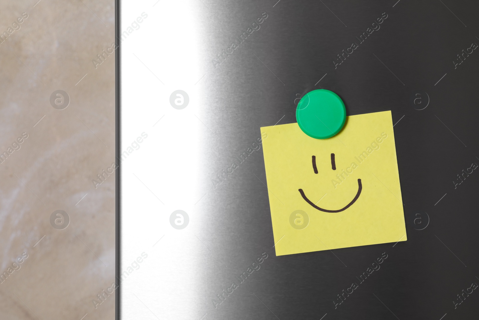 Photo of Note with funny face on refrigerator door