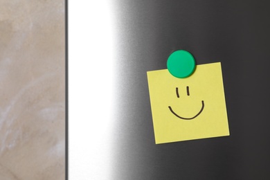 Note with funny face on refrigerator door