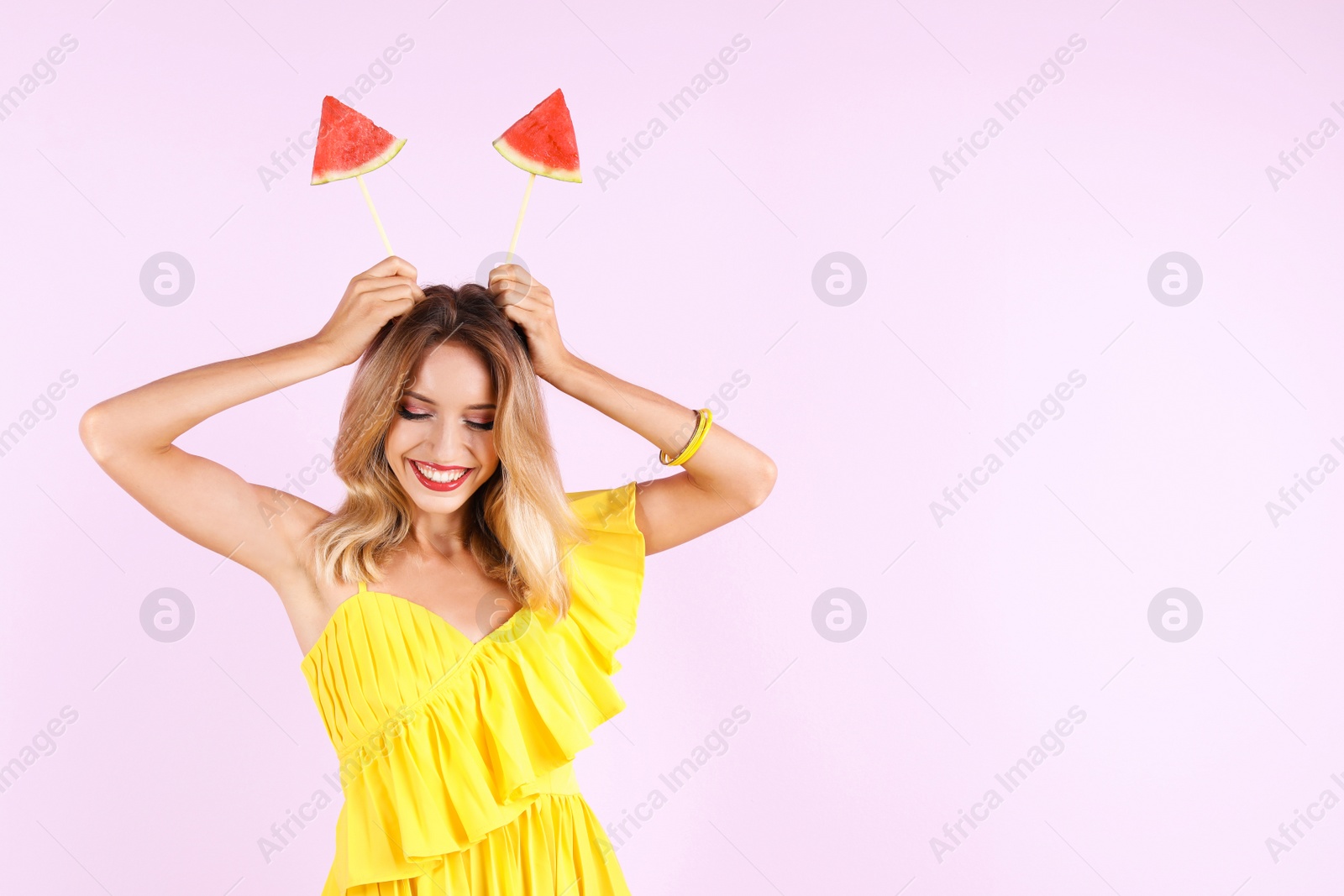 Photo of Pretty young woman with juicy watermelon on color background