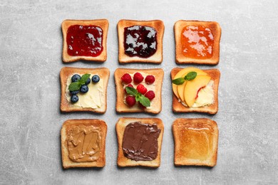 Photo of Tasty toasts with different spreads and fruits on light grey table, flat lay