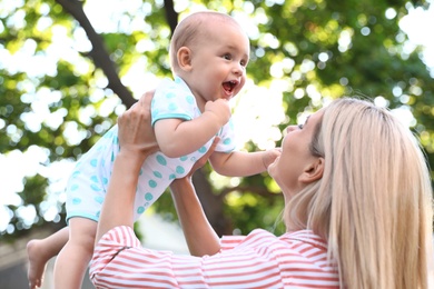 Photo of Nanny with cute baby outdoors on sunny day