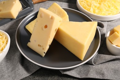 Photo of Grated and whole pieces of cheese on table, closeup