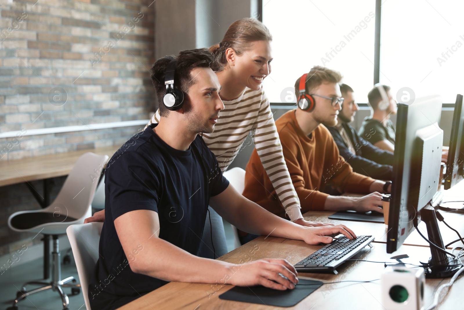 Photo of Group of people playing video games in internet cafe