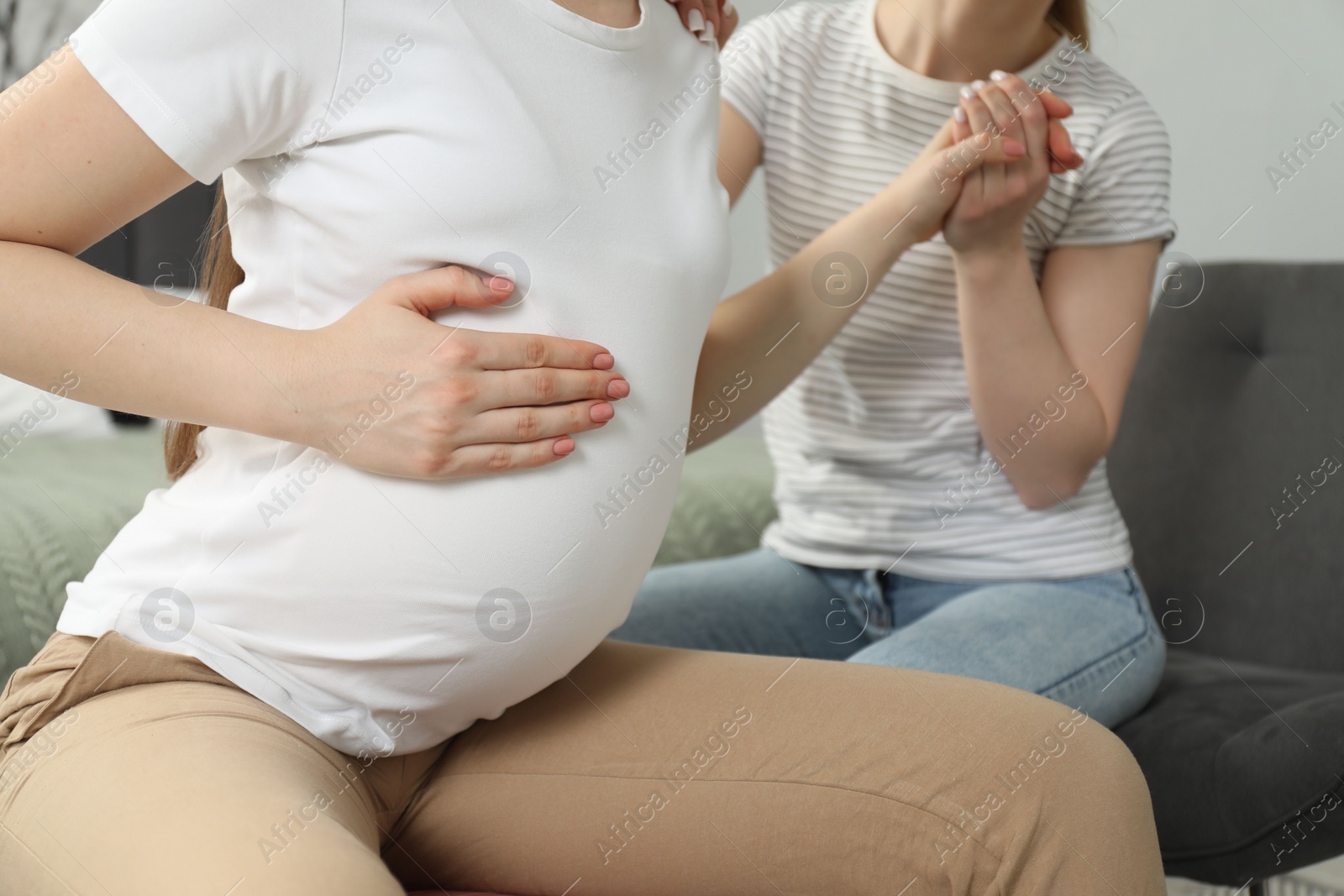 Photo of Doula taking care of pregnant woman indoors, closeup. Preparation for child birth