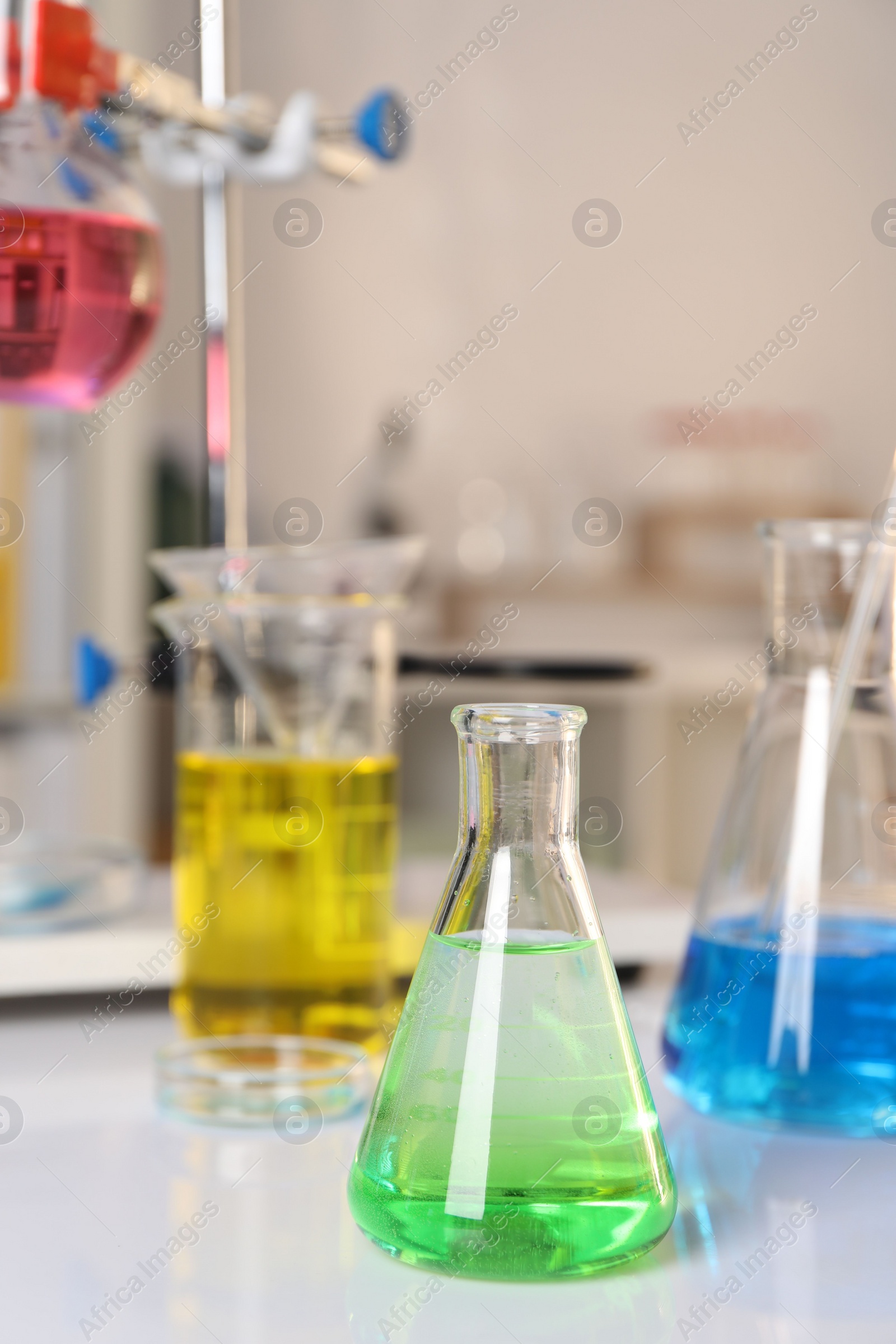 Photo of Laboratory analysis. Glassware with different liquids on white table indoors