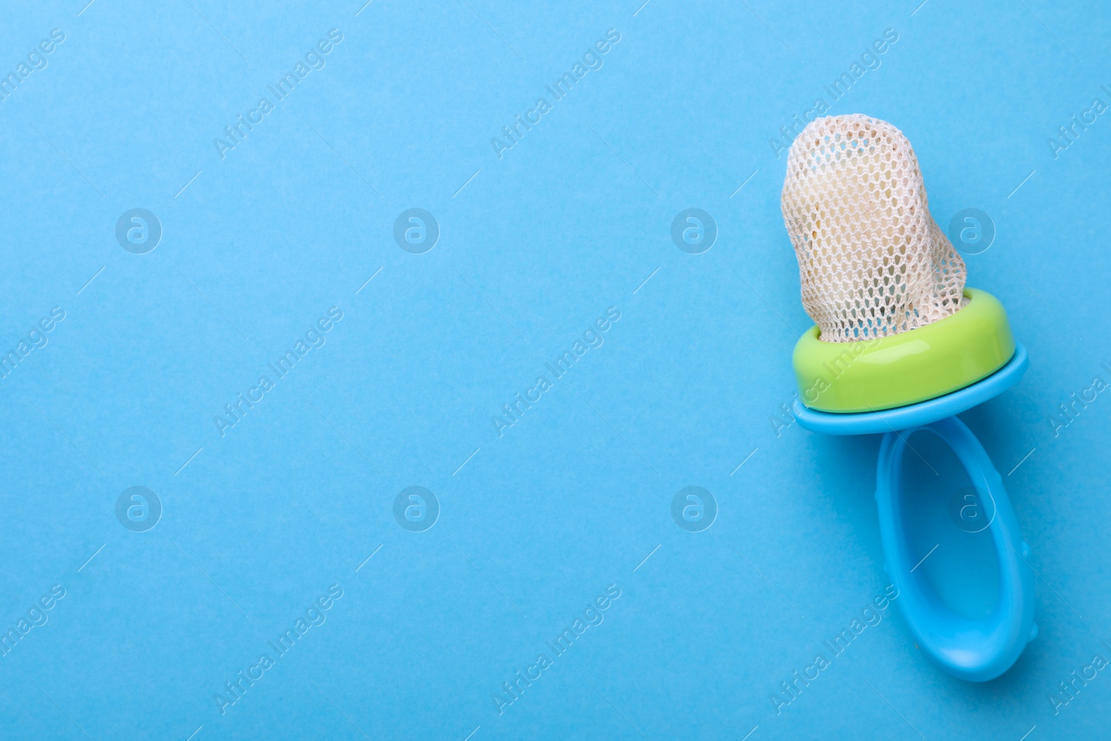 Photo of Nibbler with pear on light blue background, top view. Space for text